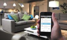 Un usuario utiliza su telèfono inteligente en una casa